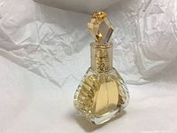 Front angled view of the faceted glass perfume bottle with gold gem-like cap