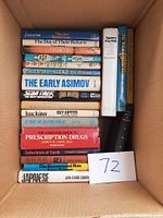 Stack of 14 assorted hardcover books displaying titles and authors on spines.