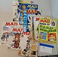 Photo of a collection of vintage MAD magazines showing various issues and special editions with colorful covers and comic-style art.