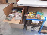 Four boxes of assorted science fiction periodicals with colorful vintage covers shown from the top and side.