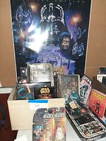 Overview showing Special Edition poster behind open box containing magazines, books and two MOC figures