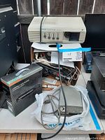 Epson EMP-7200 video projector, Sylvania Compact DVD player box, cables and accessories on table.