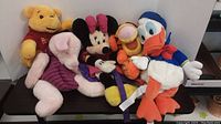 Full view of all five character plush backpacks grouped together on a surface, showing colors and details.