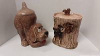 Full view of both ceramic cookie jars, dog shaped and squirrel/tree stump shaped
