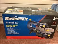 Closed box showing Mastercraft 16 inch scroll saw with key features and image of saw on box.