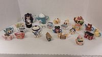 Full display of all 21 miniature teapots and figurines arranged on white background