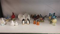 Front view of 7 pairs and 1 single salt and pepper shakers featuring various bird designs and a fish.