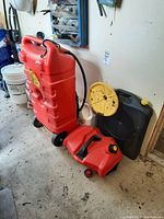Red wheeled gas can with attached hose and handle, large and portable for safe transport of fuel