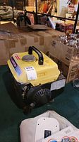 Overall view of the Launtop LT950DC generator showing yellow top with black handle and base on carpeted floor.