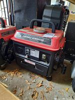 Front and side view of red and black Storm Cat portable generator, showing control panel, outlets, warning labels, and recoil starter.