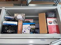 Overview of lot showing various security and electronic devices arranged inside a cabinet including a car radio, lock devices, and the FishHunter box.
