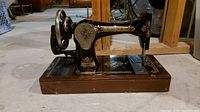 Singer sewing machine on wooden base, front view