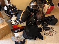 Lot overview showing all helmets and accessories including gloves, visors, headset, and bags.