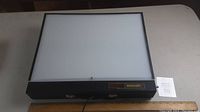 Front view of the Bretford Acculight light table powered off, showing black frame and white translucent surface with label.