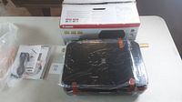 Canon PIXMA MP495 printer still sealed in plastic wrap on a table with its box and manuals.