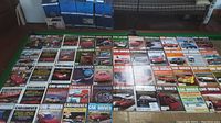 Photo showing 40 Car and Driver magazines arranged in 4 rows on a green surface. Covers depict various classic cars and automotive features.