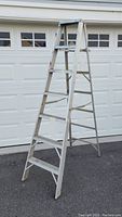 Full view of the 7 foot aluminum step ladder standing open and showing all steps.