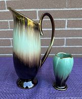 Photo of two West German ceramic vases, one tall brown and turquoise gradient pitcher vase with handle and one smaller turquoise gradient vase