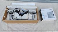 Overview of Oculus Quest 2 headset, controllers, cable and ASUS ZenDrive 8X box in packaging