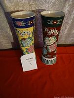 Photo of two Chinese vintage vases, one yellow and one red, showing front floral designs and blue and green decorative bands near rim and base.