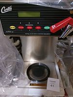 Front view of Curtis commercial coffee pot showing control panel with buttons and digital screen, red brew handle visible