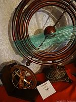 Large armillary sphere with wooden rings and spherical pendulum, and a smaller armillary sphere with brass bands on wooden base, displayed together.