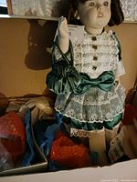 Francine Cee porcelain doll shown from front wearing emerald green satin dress with white lace