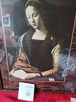 Full view of framed art print showing Mary Magdalene reading, with noticeable glare and reflection on glass.