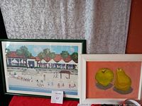 Two framed wall art pieces including a beach scene and still life fruit painting, shown side by side.
