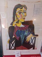 Close up photo of the Picasso wall print showing the abstract cubist portrait in strong colors framed under glass.