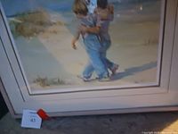 Photo showing the full wall print of two children walking on the beach with rocks and water background
