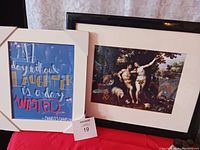 Two framed wall prints shown: Adam and Eve print with black frame and white mat, and a colorful framed quote print.