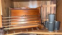 Photo of the wooden rack, bread box, crate, and four Bennington pottery mugs on a shelf.