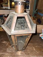 Front and top angled view of vintage copper wall sconce showing glass panels, hinged door with latch, and upper ventilation crown