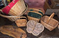 Collection of various woven baskets including Longaberger baskets and solid wood wall rack.