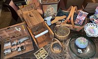 Photo showing the wooden outhouse toilet paper holder, travel grooming kit in brown case, Longaberger baskets, small wooden and ceramic decorative items including small nest and twig decoration.