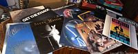 Multiple vinyl records spread out showing covers for Get The Knack, Steve Martin, Frampton Comes Alive!, Tom Petty Full Moon Fever, Anne Murray, Dragon Fly by Jefferson Starship, Rare Earth, and one partially visible record.