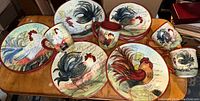 Top view of the rooster-themed plates and mugs on a wooden table.