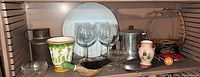 Shelf with assorted vintage decor items including glassware, pottery, and figurines