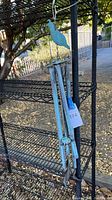 Full view of the metal pheasant themed windchimes hanging on a black metal shelf outdoors, showing the overall length and design