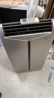 Front view of the Sharp portable air conditioner unit showing vents and control panel.