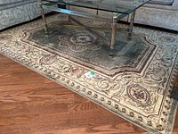 Full view of area rug under glass coffee table on hardwood floor