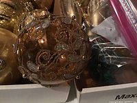 Close-up of gold Christmas ball ornament with bead and floral embellishments.