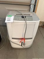 Front view of Frigidaire dehumidifier with filter vent, control panel, power cord placed loosely on top.