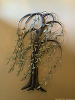 Full front view of the metal tree wall decor, showing the hanging branches and leaves.