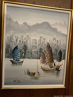 Full view of framed acrylic painting showing Chinese junks, city buildings, and mountains