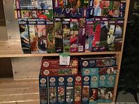 Multiple boxed puzzles stacked showing various titles, all between 300 and 500 pieces, including many Cobble Hill branded puzzles with animal and nature themes.