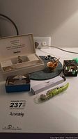 Photo showing Neiman Marcus coffee clip and measuring spoon boxed set, turtle mint holder with tongs, wine bottle opener, and other items on table.