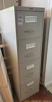 Front angled view of the ProSource four drawer filing cabinet showing four drawers and label holders.