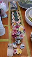 Top-down view of floral ceramic baskets and loose ceramic flowers on table